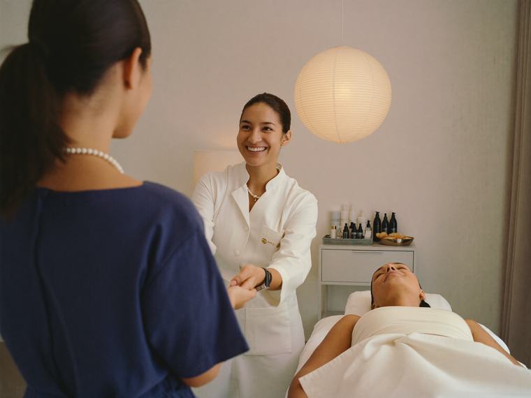 Esteticista recibiendo a su clienta en una clínica estética que agenda citas con Mallbrick